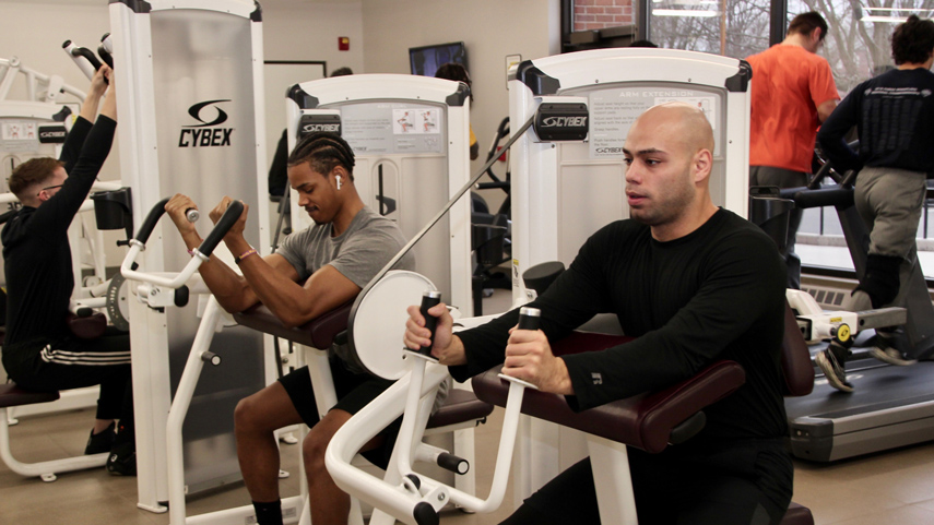students working out on machines in fitness center