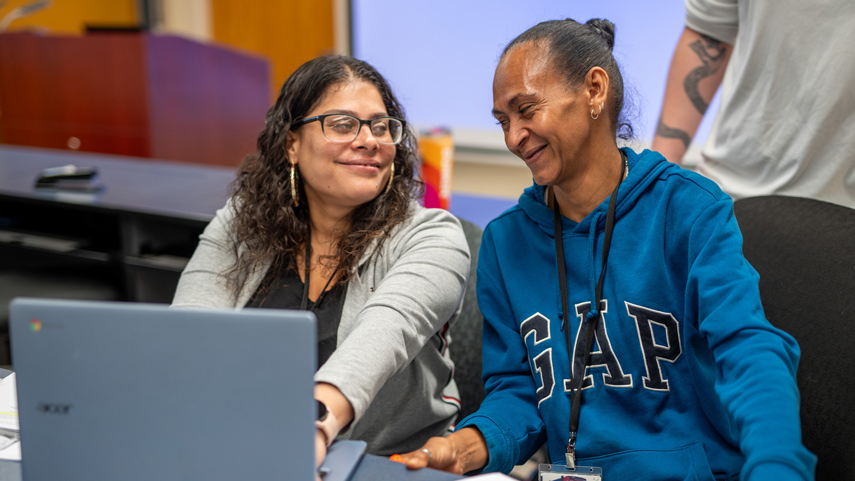 adult students at laptop working together