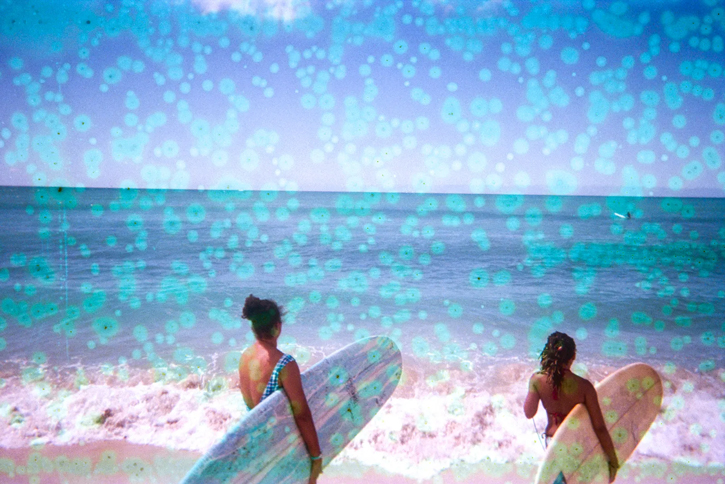 two surfers running to the ocean surfboard in hand photo is marked by light blue dots