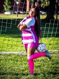Yeny Mejia holding soccer ball up with her calf behind her back
