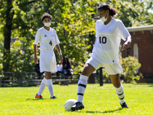 womens soccer player passing ball