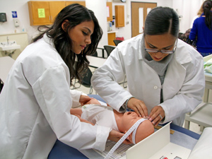 healthcare students measuring a baby's head in simulation