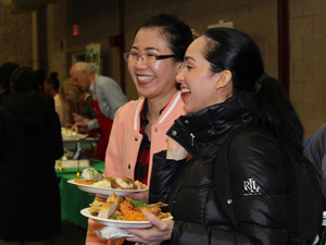 students with plates of food at the multicultural luncheon