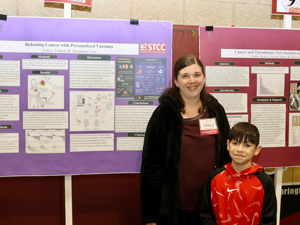 student with child in front of poster presentation