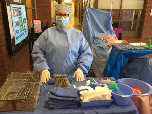 Surgical Technology instructor in scrubs with surgical lab equipment