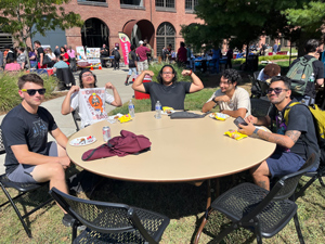 students at a picnic table at welcoming picnic