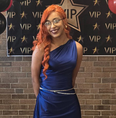 Sha'myaa Roth in dress in front of VIP board