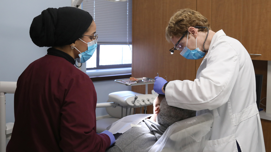 dentist and assistant cleaning a community patient's teeth