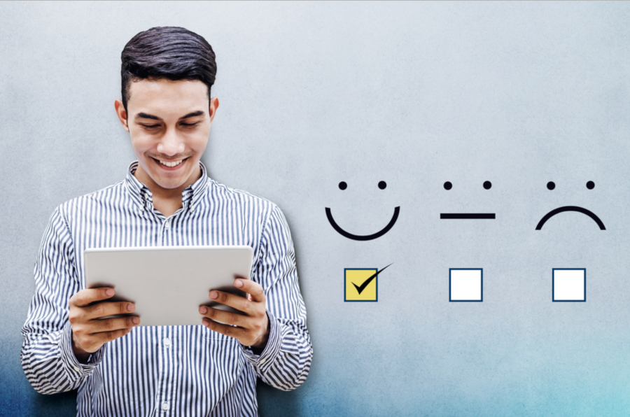 student holding tablet and smile to frown faces with checkboxes