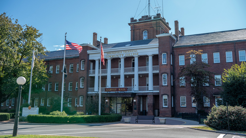 Garvey Hall entrance with columns and flags waving