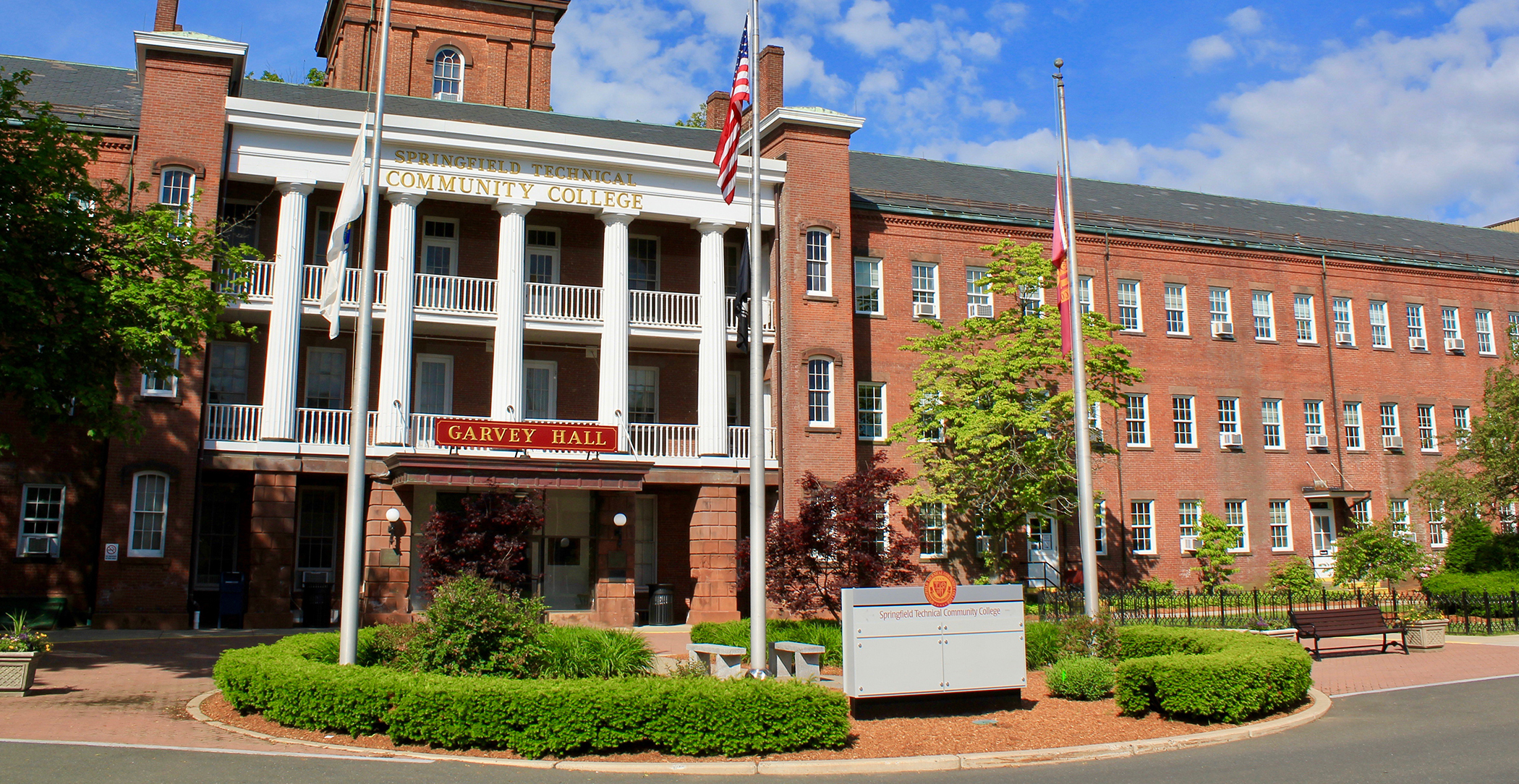Front entrance of Garvey Hall Building 16 with flags waving