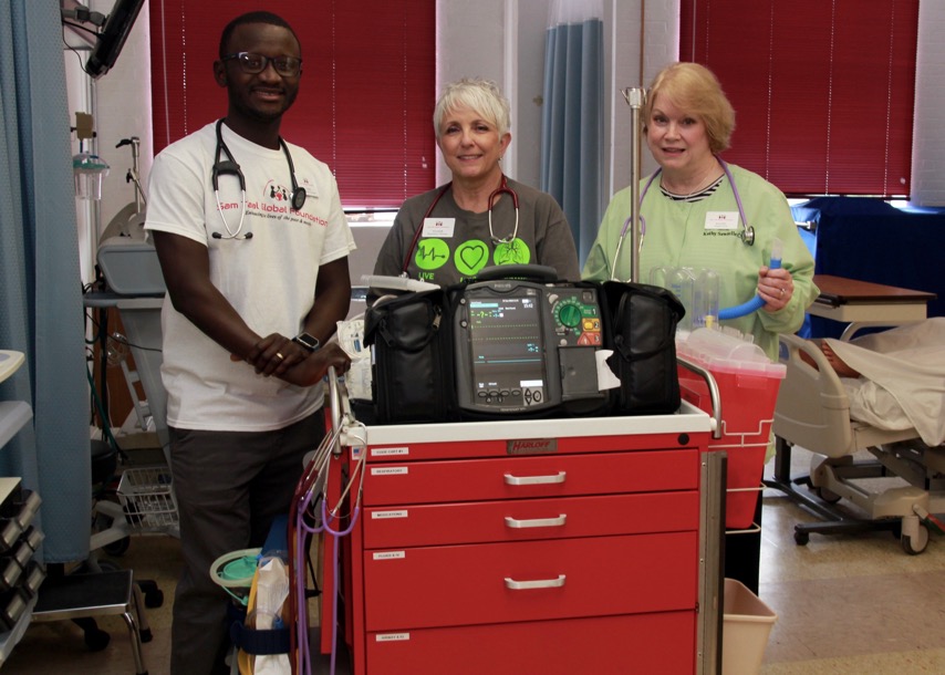 Three faculty pose behind equipment