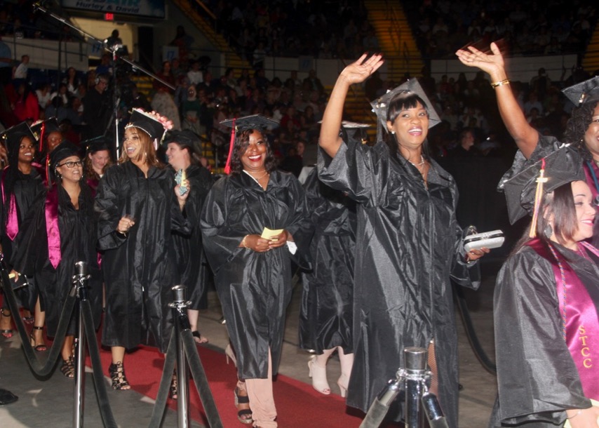 Students wave at 2019 Commencement Inside