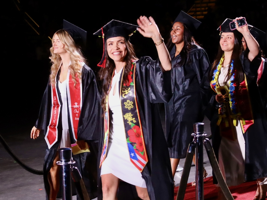 Student waves at STCC Commencement 2026