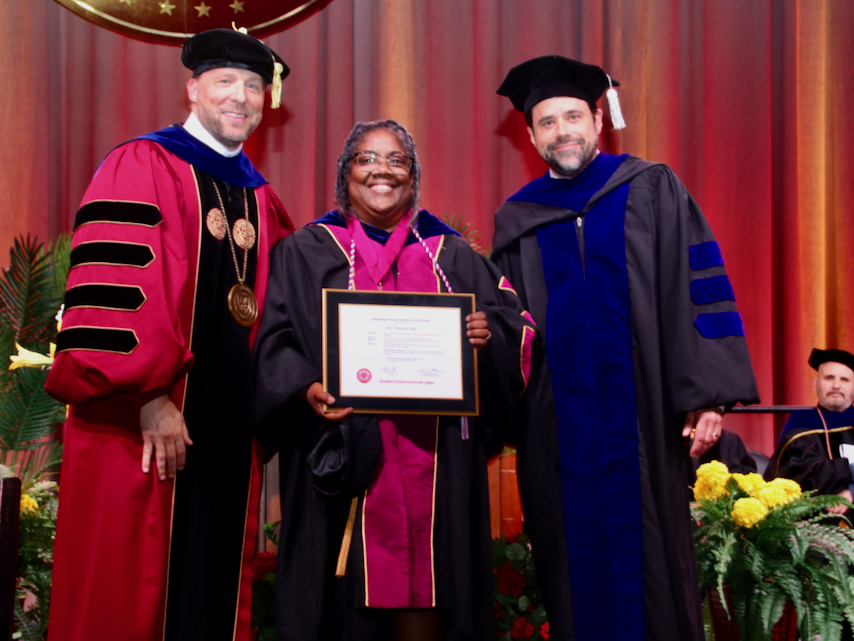Vanessa Hill holds award with President Cook, VP Thuot
