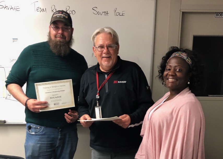 A Savage arms employee holds a certificate of completion