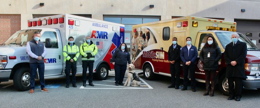 EMT AMR reps stand in front of ambulances
