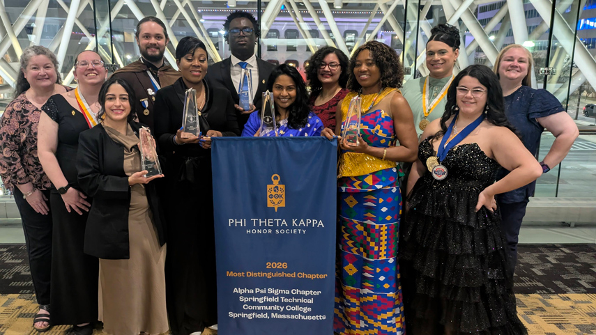 Phi Theta Kappa members at ceremony holding awards