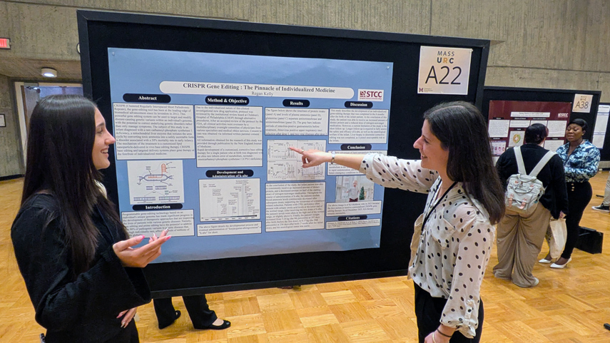 student pointing to poster presentation