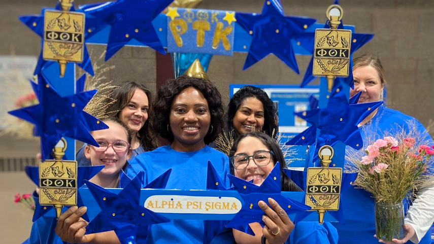 Students inside of frame that says APTK Alpha Psi Sigma
