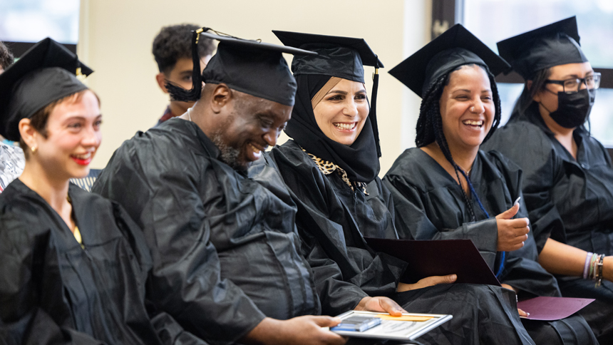 HiSET graduates sitting together dressed in caps and gowns