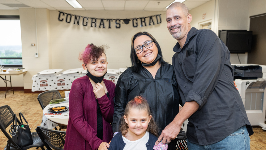 HiSET graduate with family of husband and two young girls