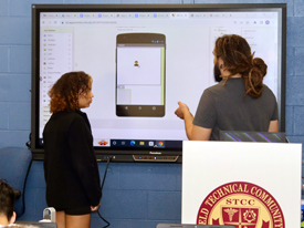 girl up at board with mobile phone displayed