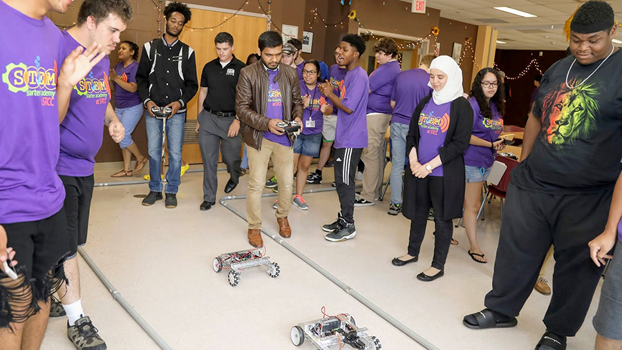 coding and robotics contestants racing remote controlled robots