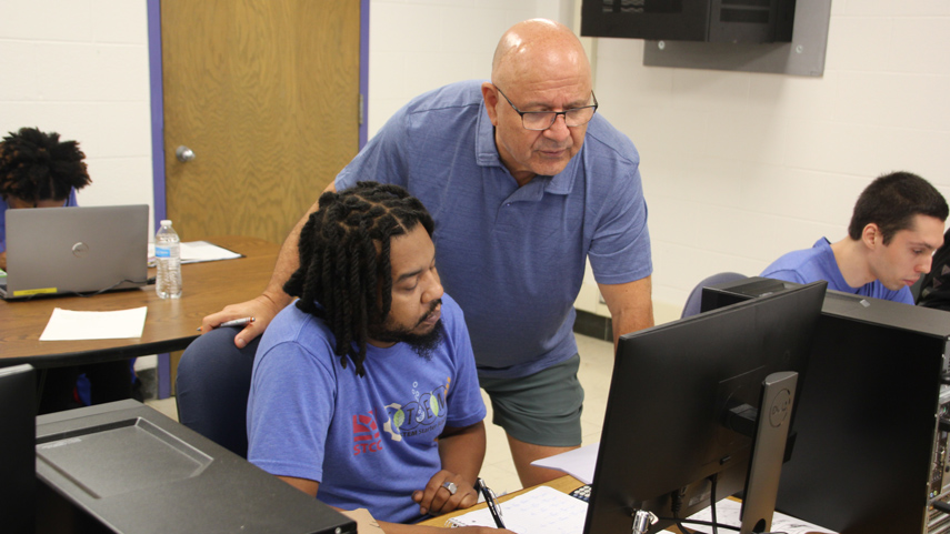 instructor and student at computer