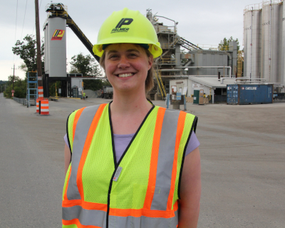 Asphalt Academy Graduate standing at paving equipment