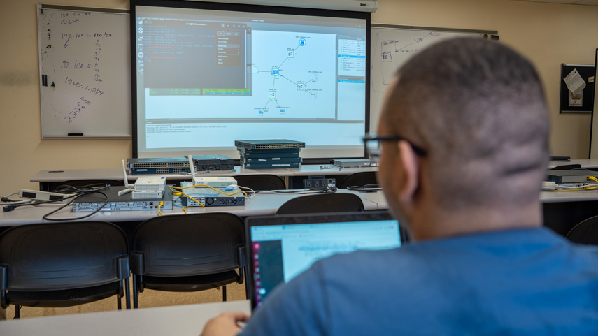 cybersecurity student on laptop at lecture