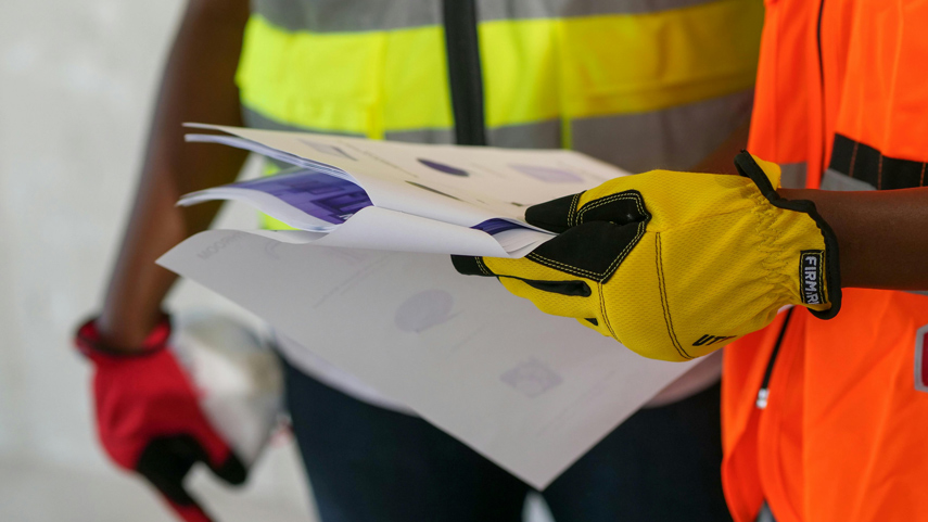 construction workers with safety gloves referring to blueprint