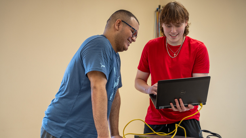 Cybersecurity students working with laptop