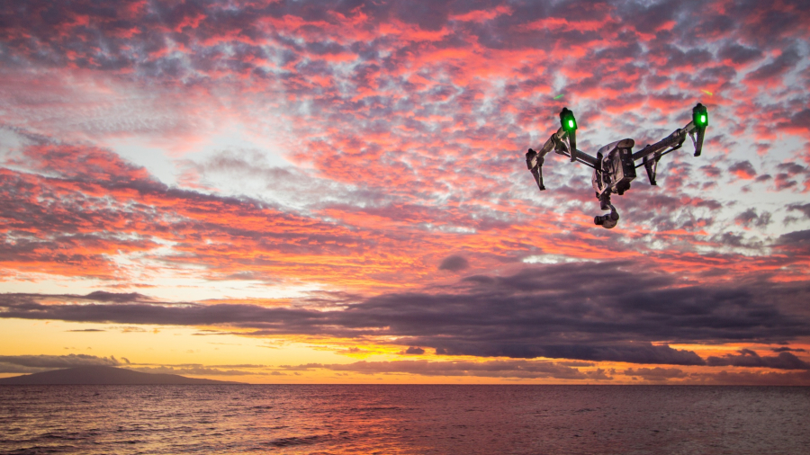 drone flying over ocean at sunset