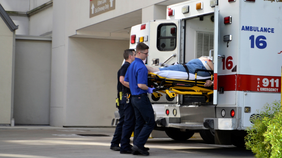 EMTs taking a patient out of an ambulance at a hospital
