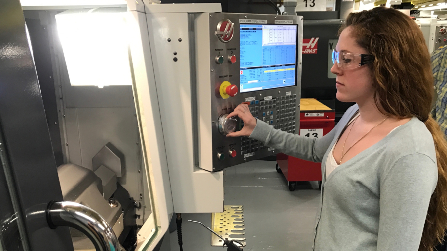 student pressing buttons on CNC Machine