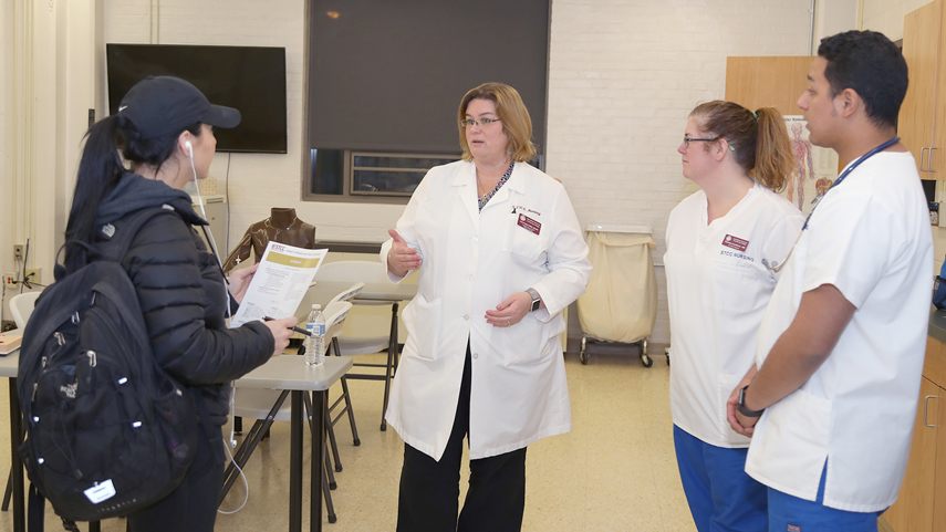 medical interpreter in lab coat speaking to student