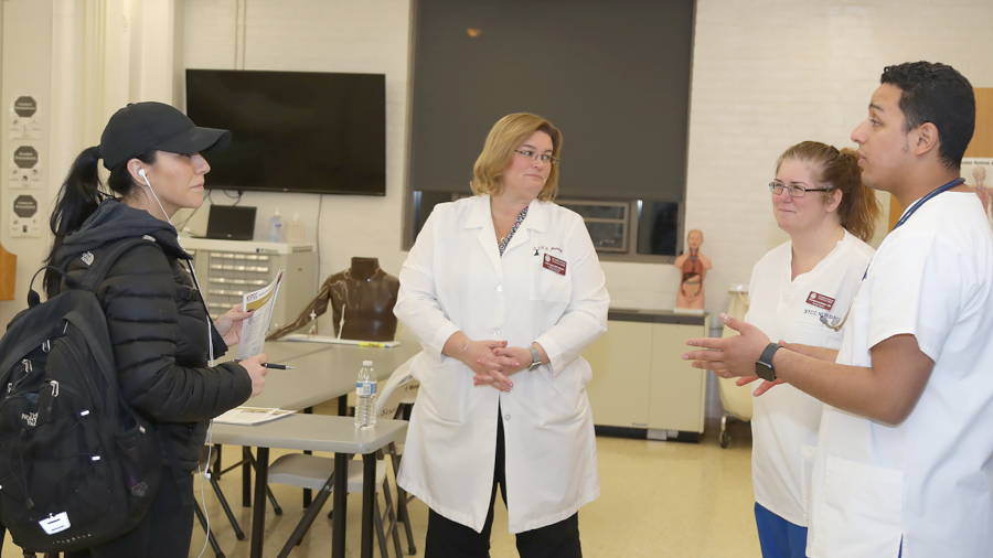 medical interpreting student in scrubs practicing with patient